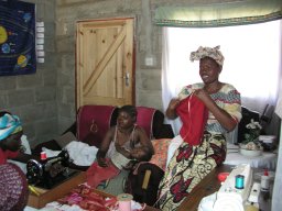 Faculty wives and femaile students sewing clothes for orphans